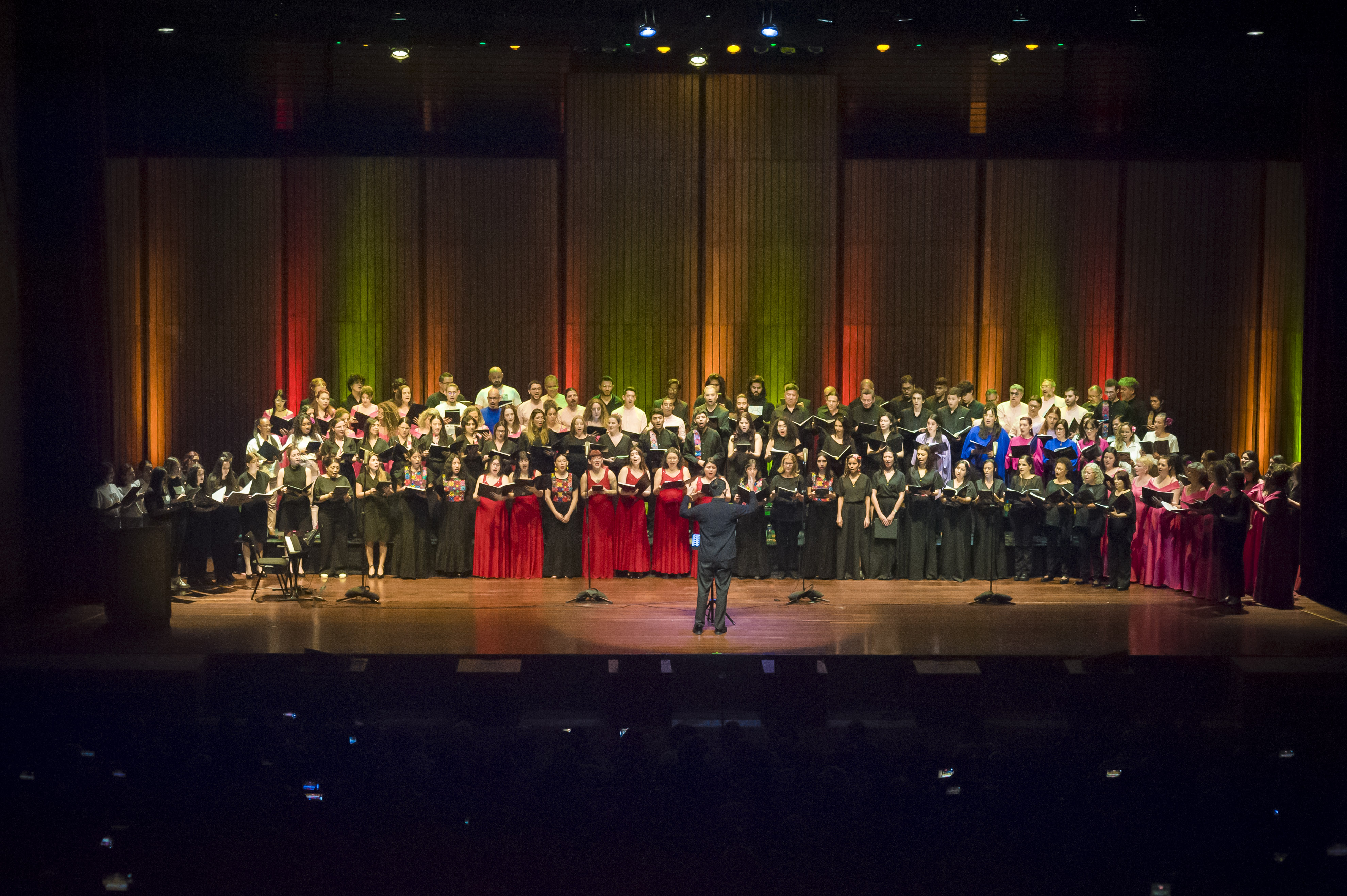 Un gran coro en un escenario iluminado.